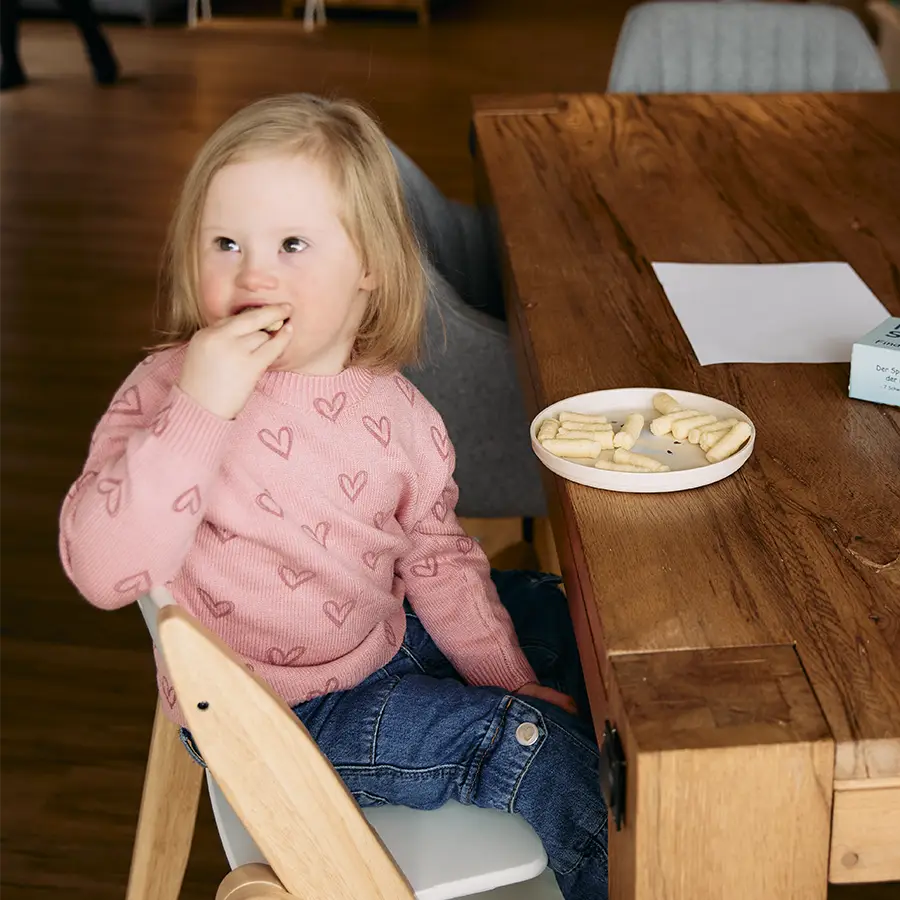 Kind probiert Snacks am Tisch